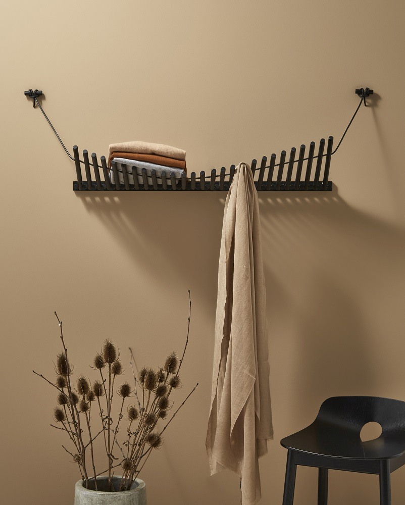 Knaegt Coat Rack Wandgarderobe von Woud in Eiche schwarz mit Kleidung und Dekoration.