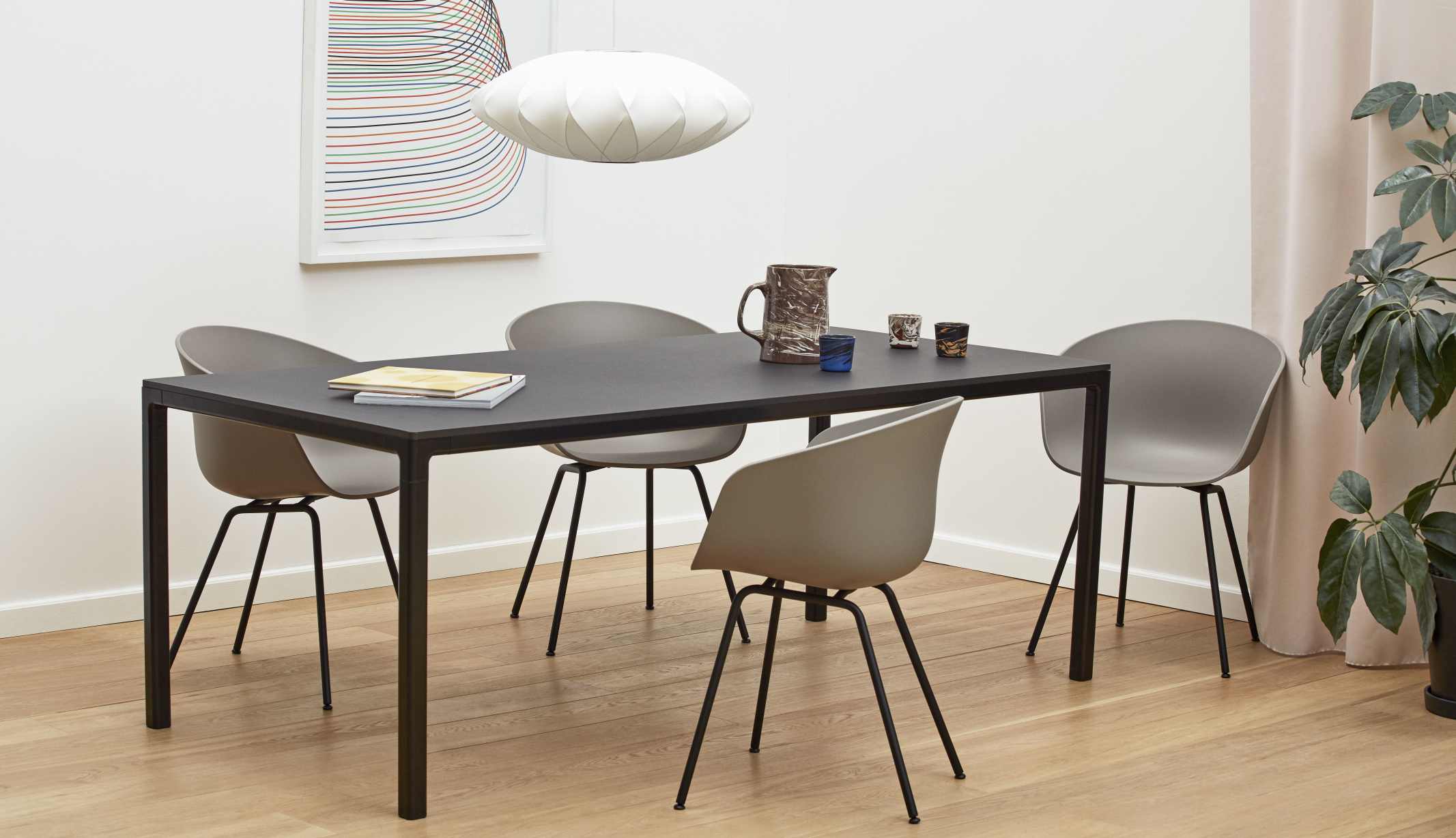 Esstisch mit vier grauen About A Chair AAC26 Stühlen von Hay, modernes Design.