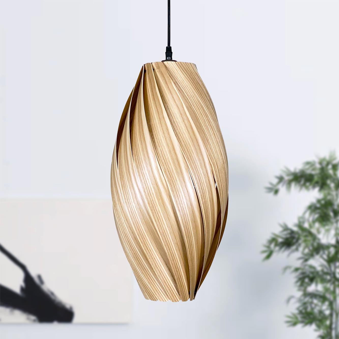 Ardére Hängeleuchte aus Olivesche von Gofurnit: Längliche Holzlampe mit gedrehtem Design für stilvolle Beleuchtung.