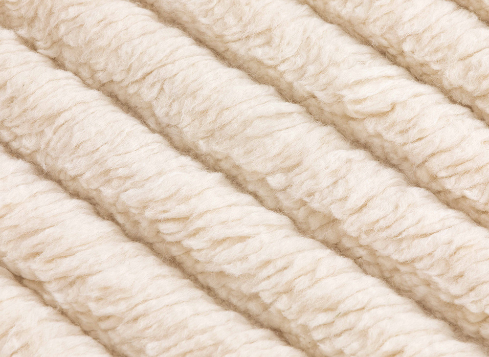 Detailaufnahme des Lines Rug Teppichs von Gan, ein cremefarbener Wollteppich mit strukturierten Linien.
