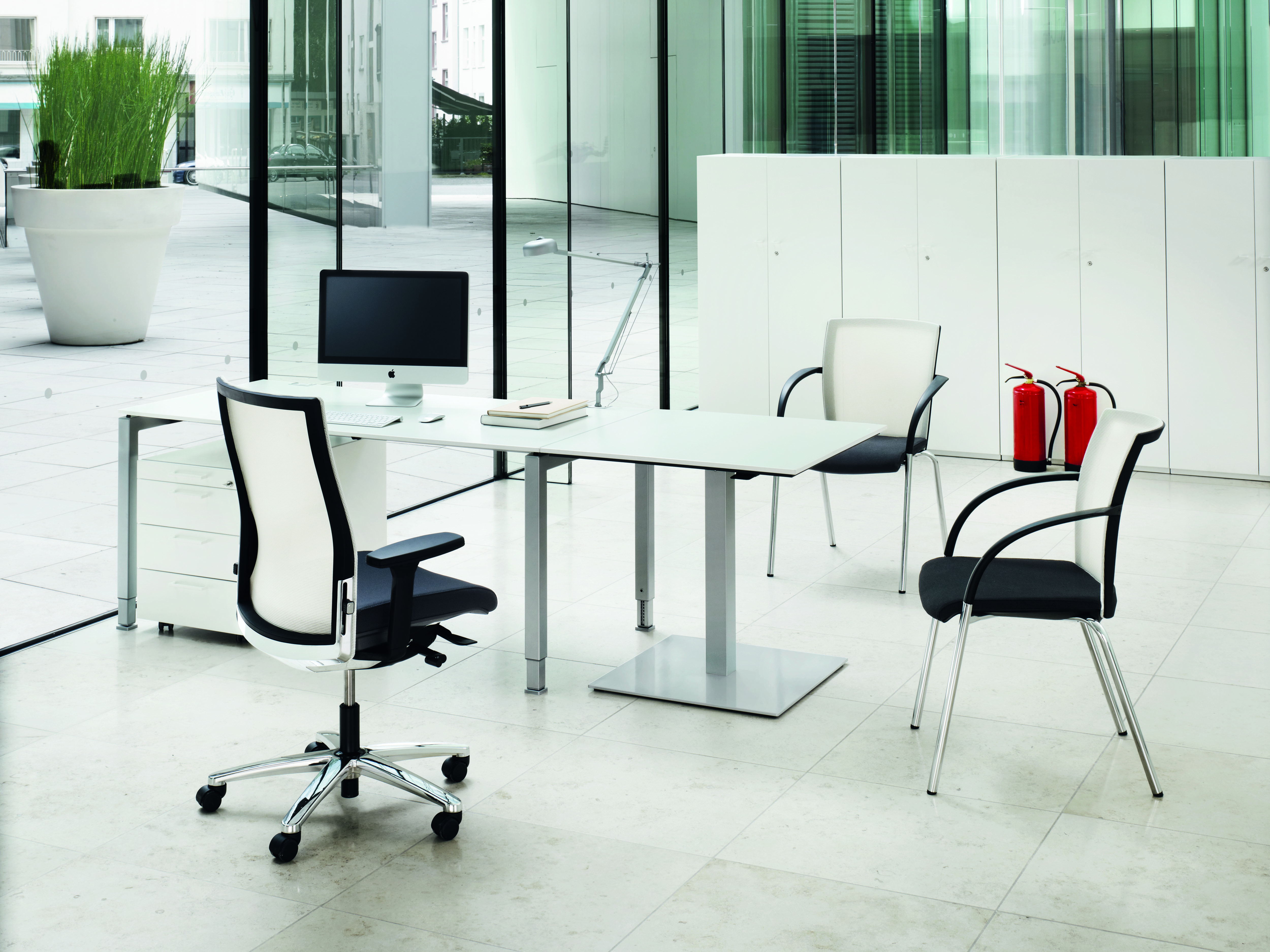 König+Neurath Schreibtisch höhenverstellbar: Moderner Bürotisch mit Bürostuhl und Besucherstühlen in hellem Büro.