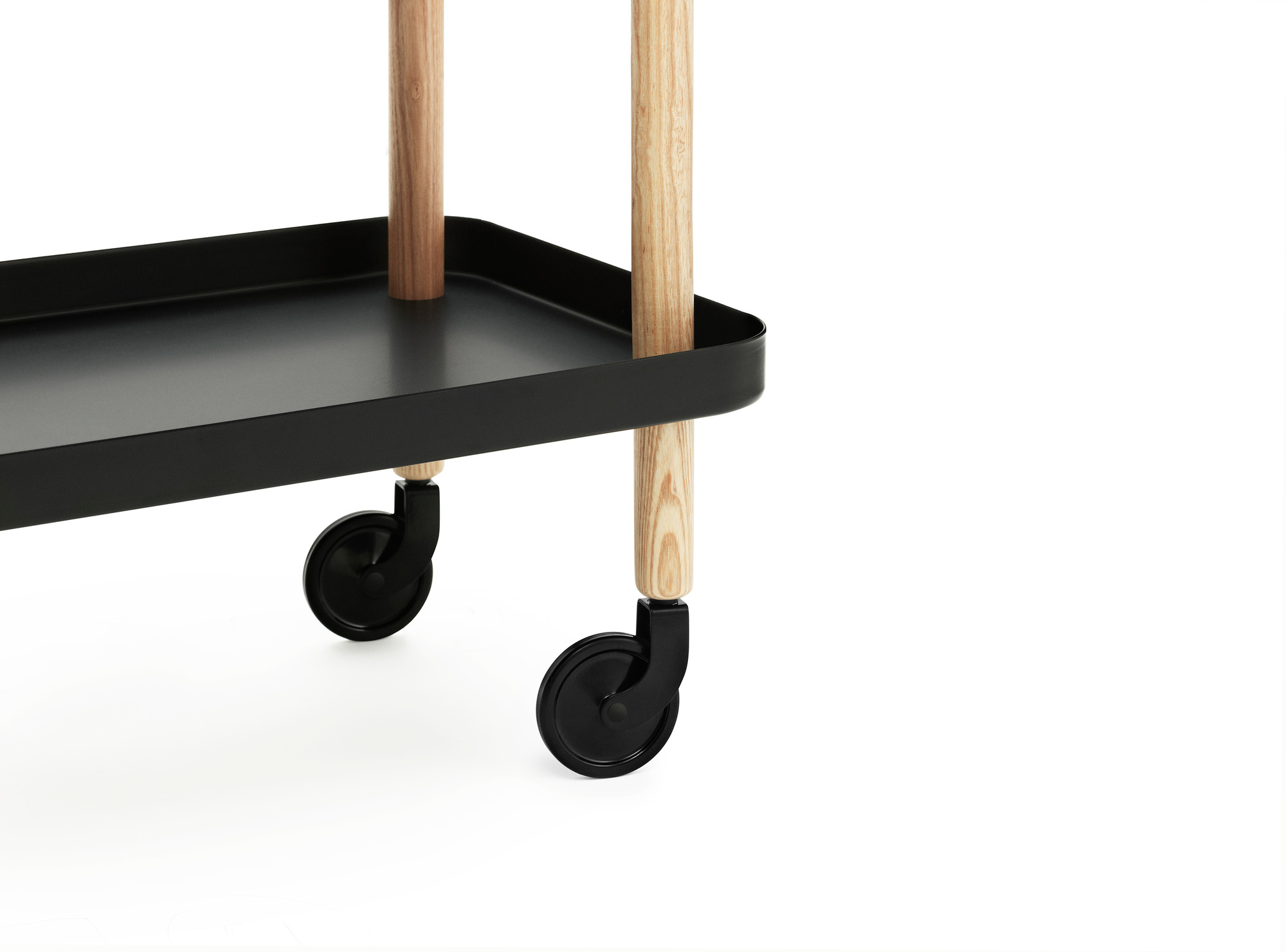 Detailaufnahme des schwarzen Normann Copenhagen Block Table Servierwagens mit Holzbeinen und Rollen.