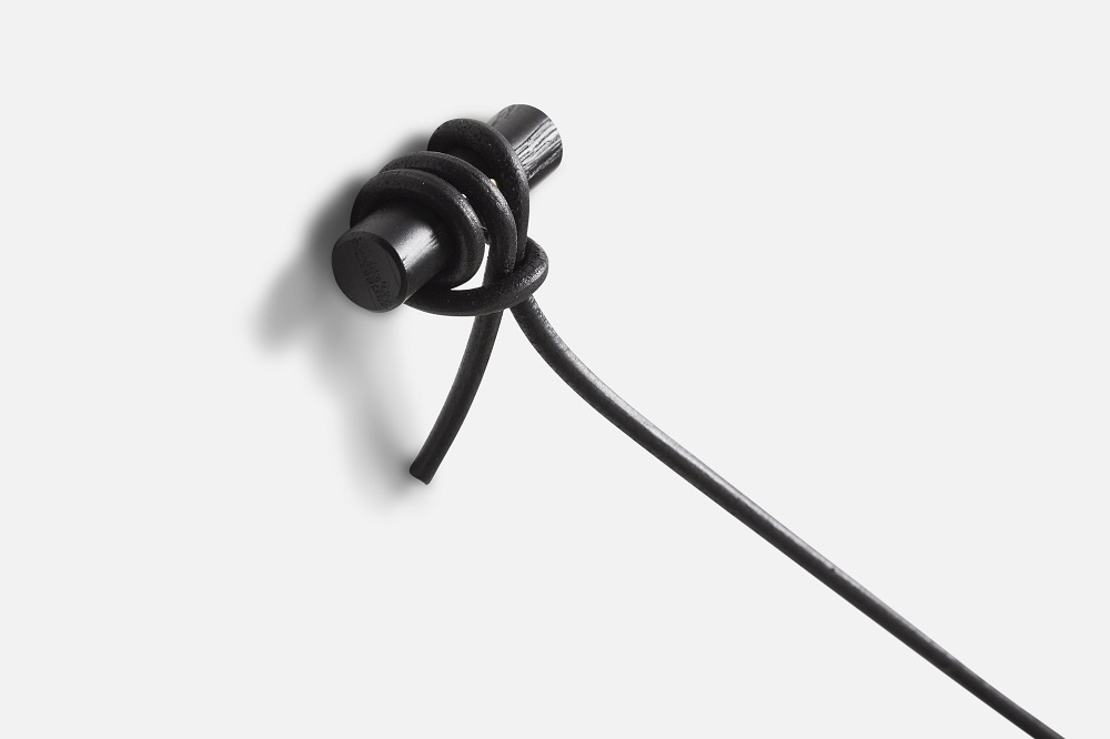 Detailaufnahme der Knaegt Garderobe von Woud: Schwarze Eiche, minimalistisches Design, Wandbefestigung.