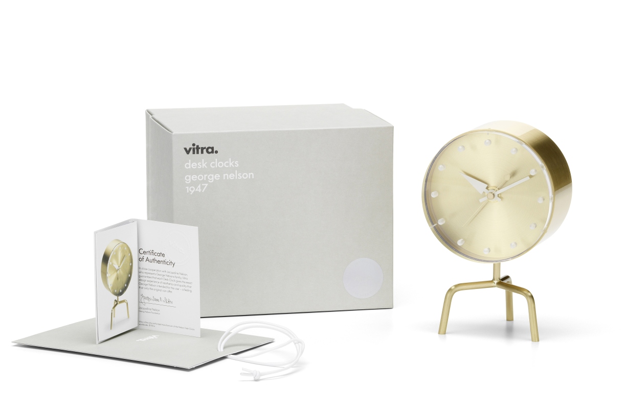 Goldene Vitra Tripod Clock Tischuhr mit drei Beinen, Verpackung und Echtheitszertifikat auf weißem Hintergrund.