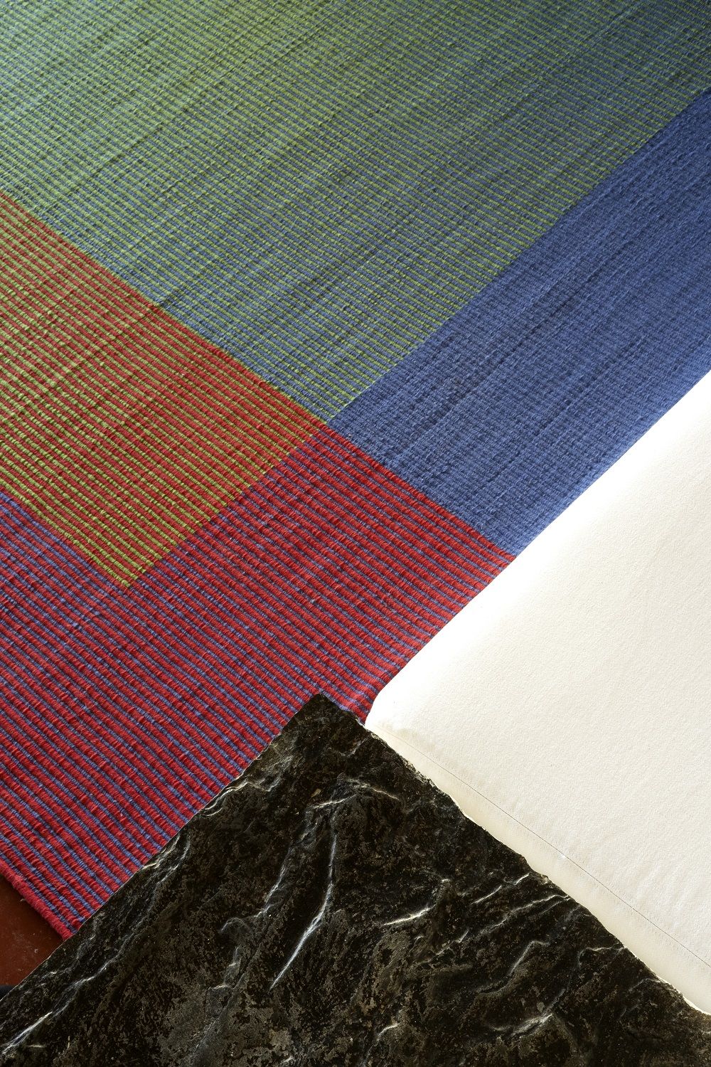 Detailaufnahme des Haze Rug Teppichs von Nanimarquina in Grün, Rot, Blau und Weiß.