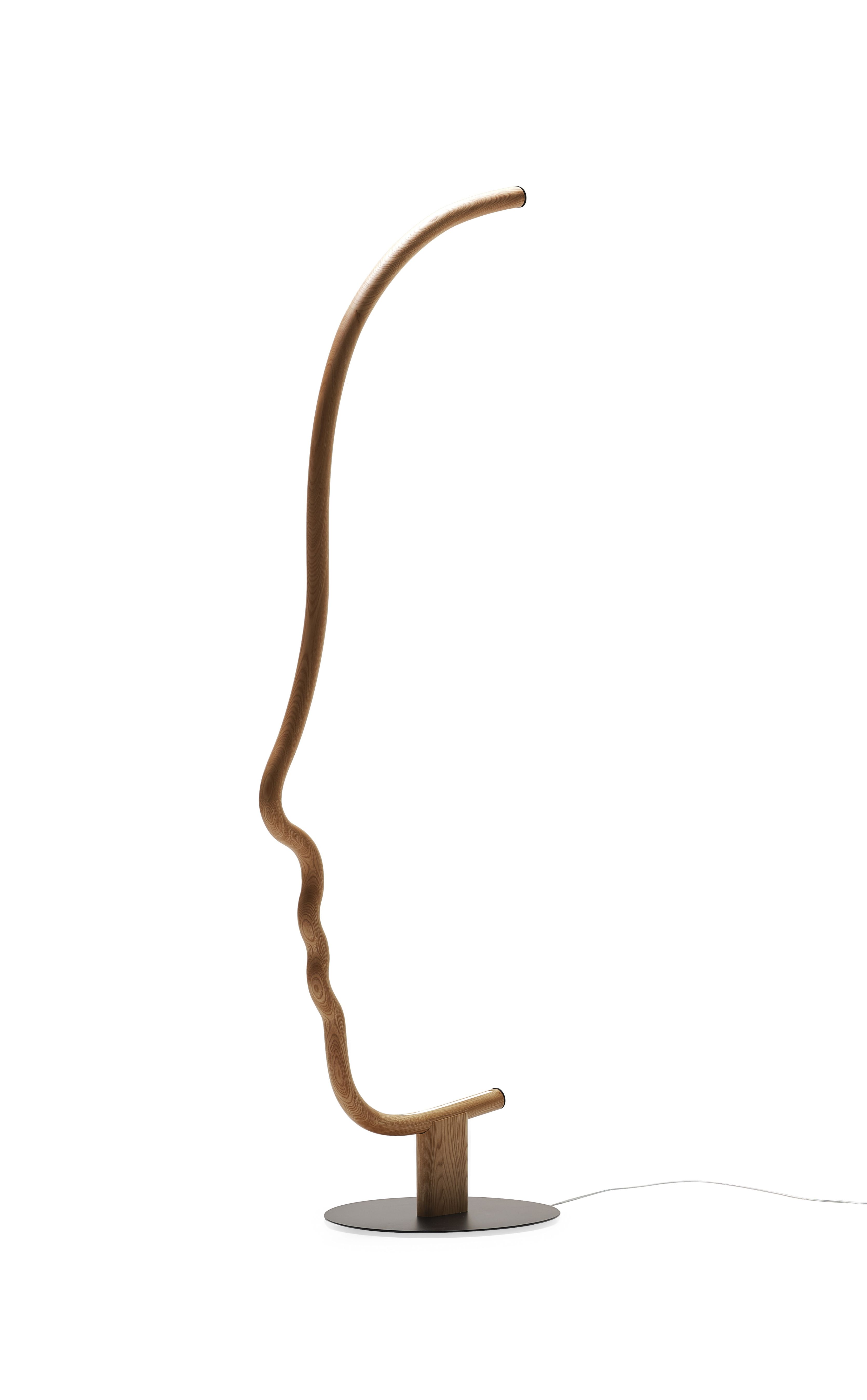 Vis a Vis Stehlampe Kastanie Mogg, moderne Designerleuchte in Form eines stilisierten Gesichtsprofils aus Holz.