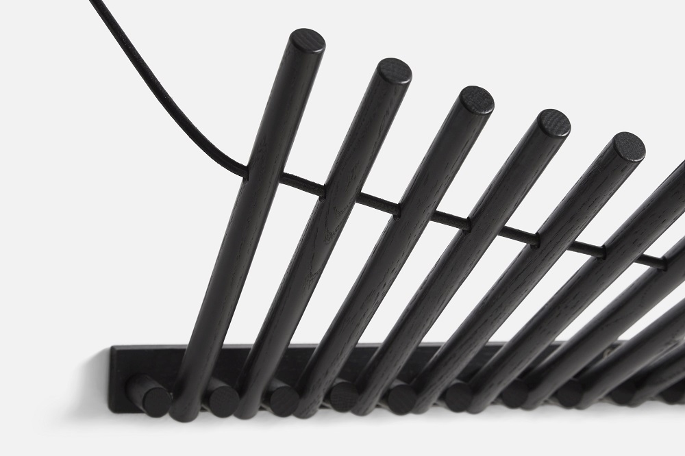 Detailaufnahme der Knaegt Wandgarderobe von Woud aus schwarzem Eichenholz, moderne Garderobenlösung für Flur und Eingangsbereich.