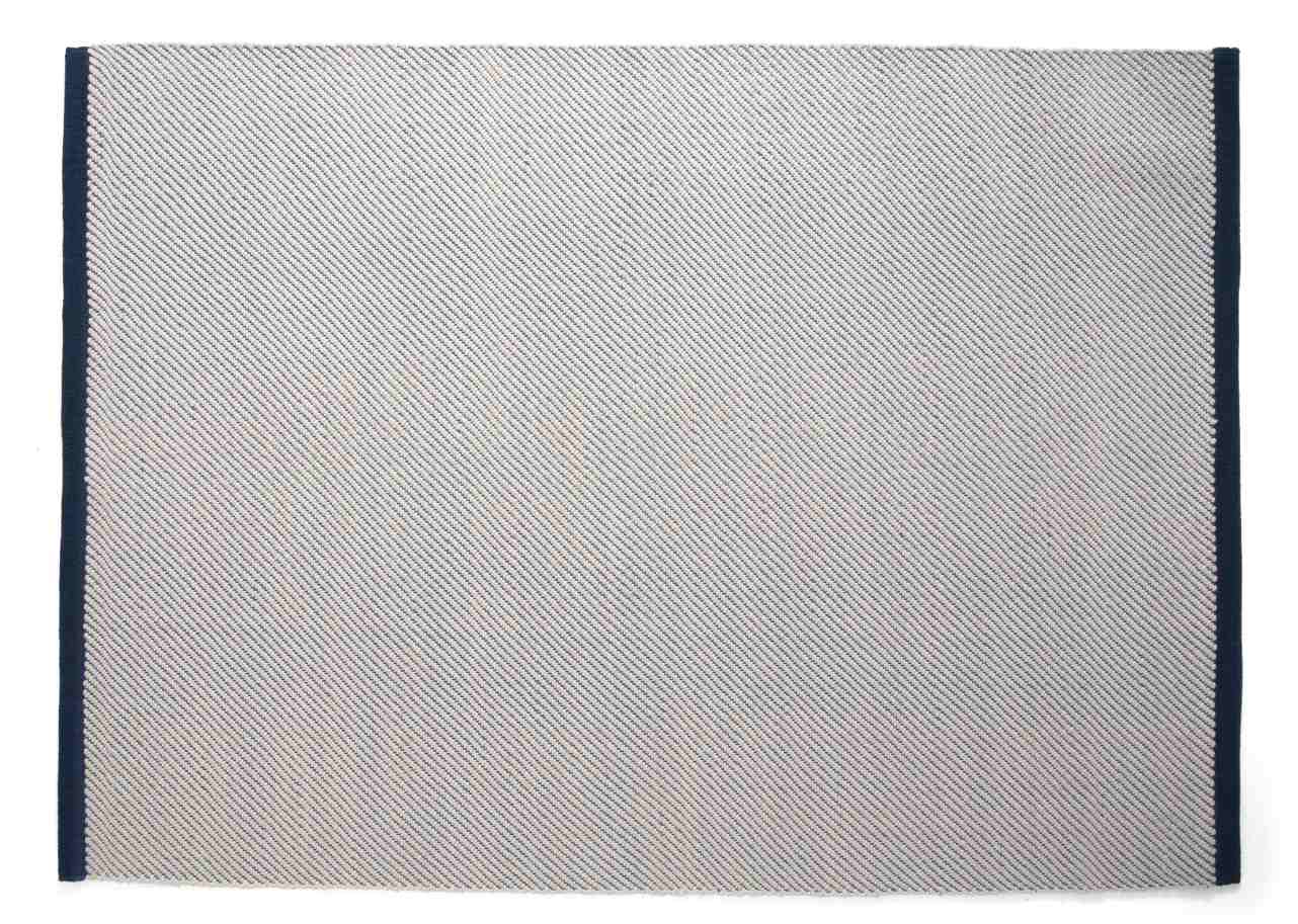 Bias Rug Tint Teppich Ocean Tint: Rechteckiger Teppich mit feinem, diagonalem Muster und dunkelblauer Umrandung.