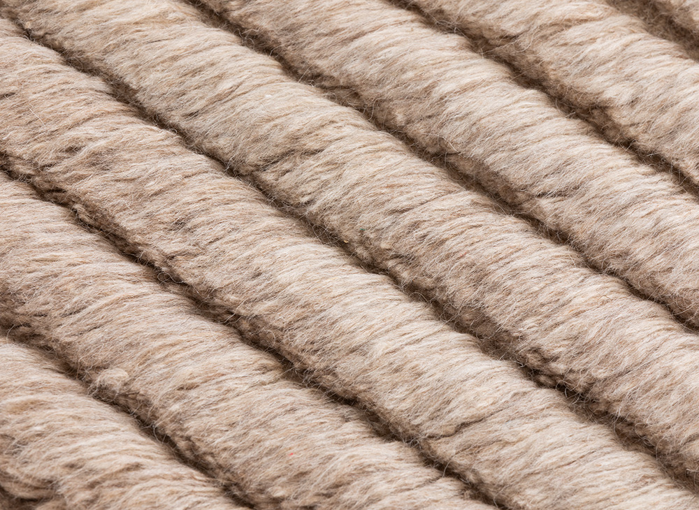 Detailaufnahme des beigen Lines Rug Teppichs von Gan, der eine strukturierte Oberfläche mit Linienmuster zeigt.