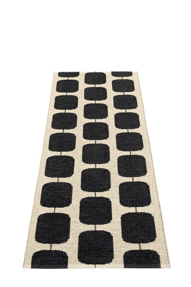 Pappelina Sten Kunststoffteppich in Schwarz/Creme mit grafischem Muster aus Rechtecken, ideal für Innen- und Außenbereich.