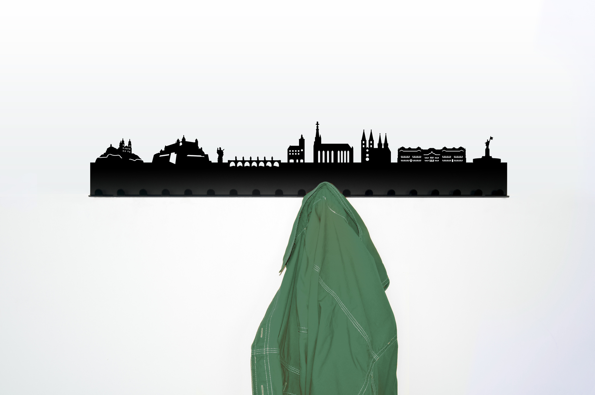 Würzburg Garderobe Radius mit Skyline als Wandhänge-Garderobe mit grüner Jacke an weißer Wand.