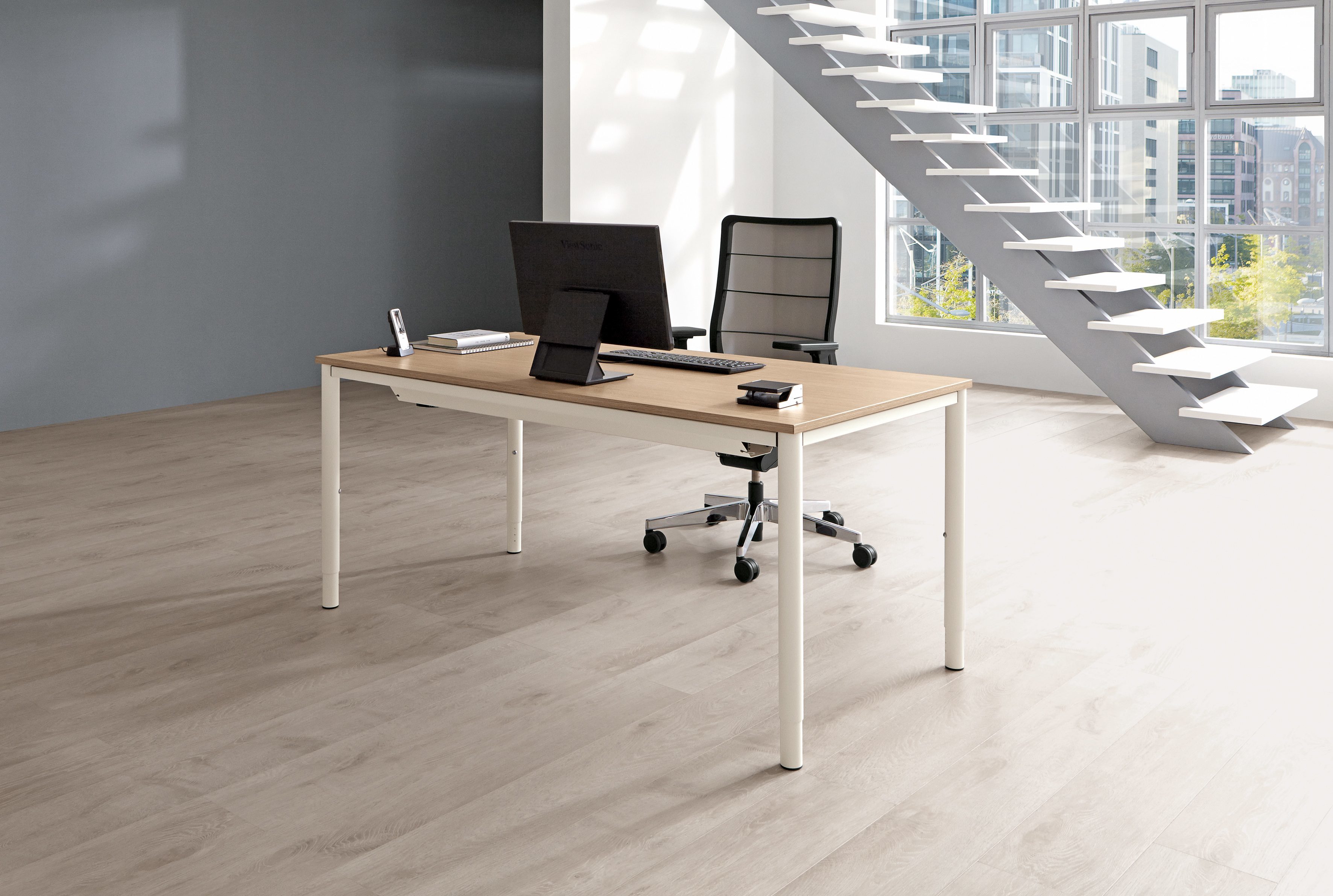 Moderner Palmberg Schreibtisch mit heller Holzplatte und weißem Gestell im Büro.