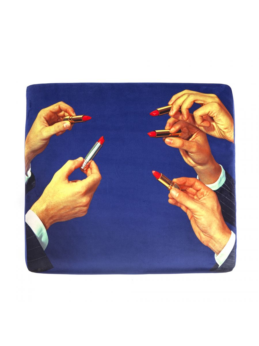 Toiletpaper Pouf Hocker Lipsticks Seletti: Quadratischer Hocker mit blauem Hintergrund und Hände, die Lippenstifte halten.