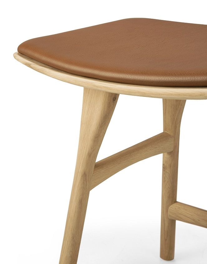 Detailaufnahme: Ethnicraft Osso Hocker aus Eiche mit braunem Leder Sitzpolster. Moderner Hocker für Wohnzimmer.