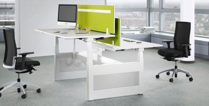 TALO.S Schreibtisch von König+Neurath: Höhenverstellbarer, weißer Bürotisch mit grüner Trennwand und zwei Bürostühlen im modernen Büro.