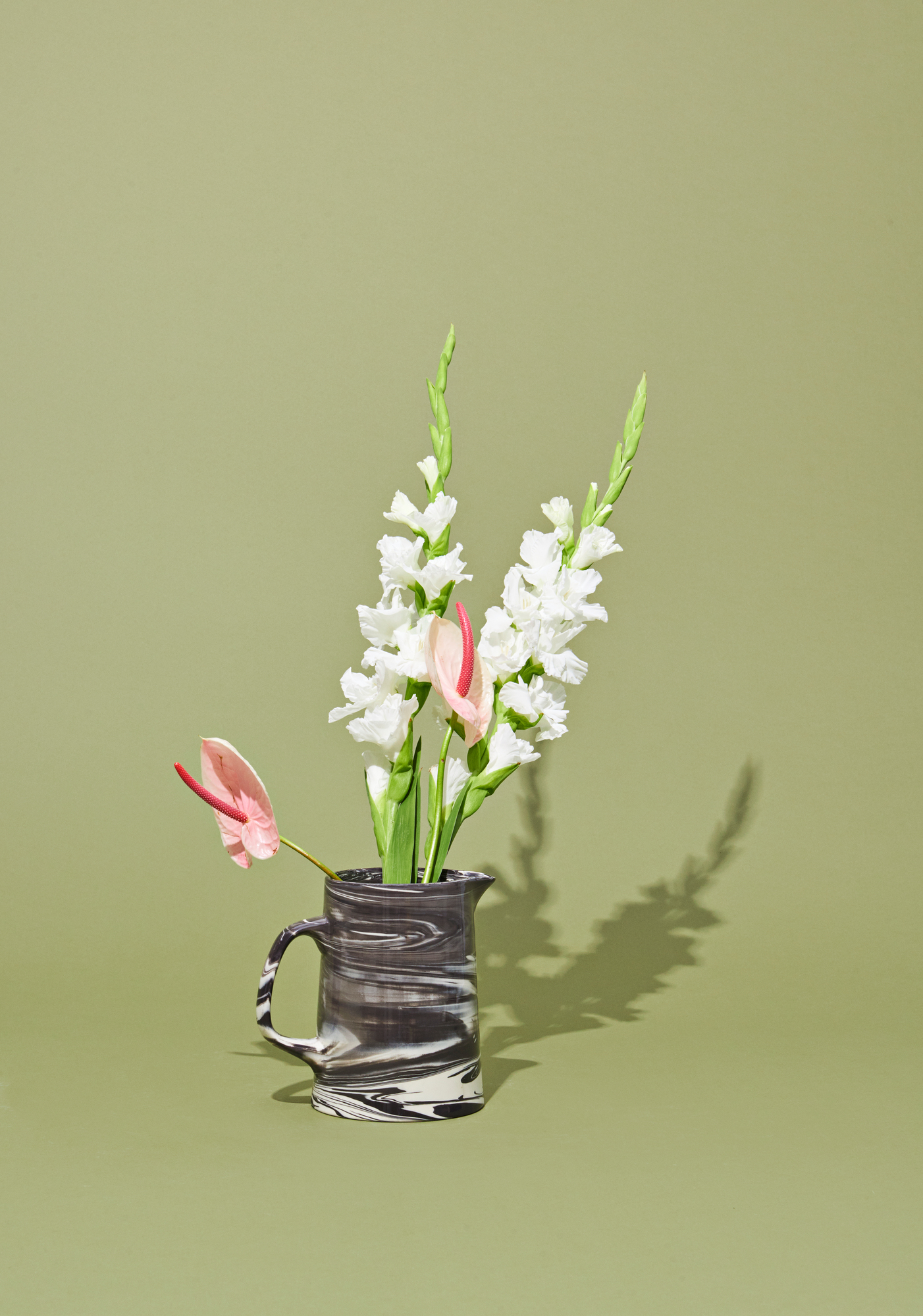 Schwarze Marbled Jug Karaffe von Hay mit Blumen auf olivgrünem Hintergrund, moderne Tischdeko.