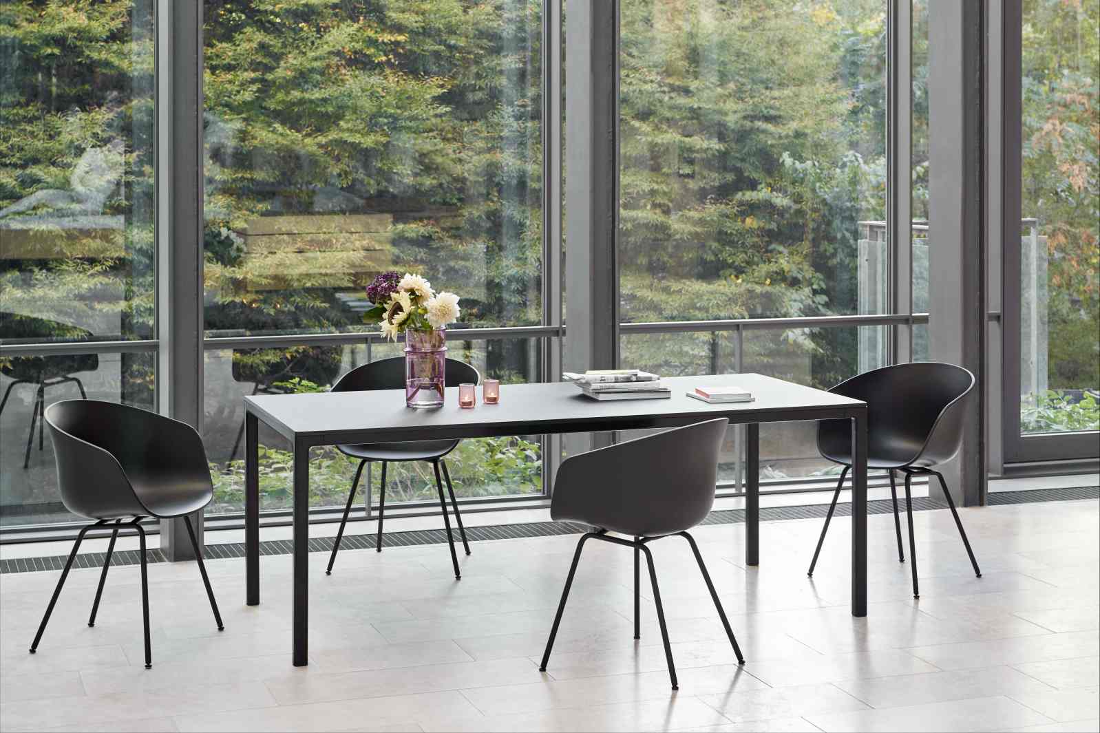 About A Chair AAC26 Stuhl in Betongrau am Esstisch vor Fensterfront. Designermöbel von Hay.