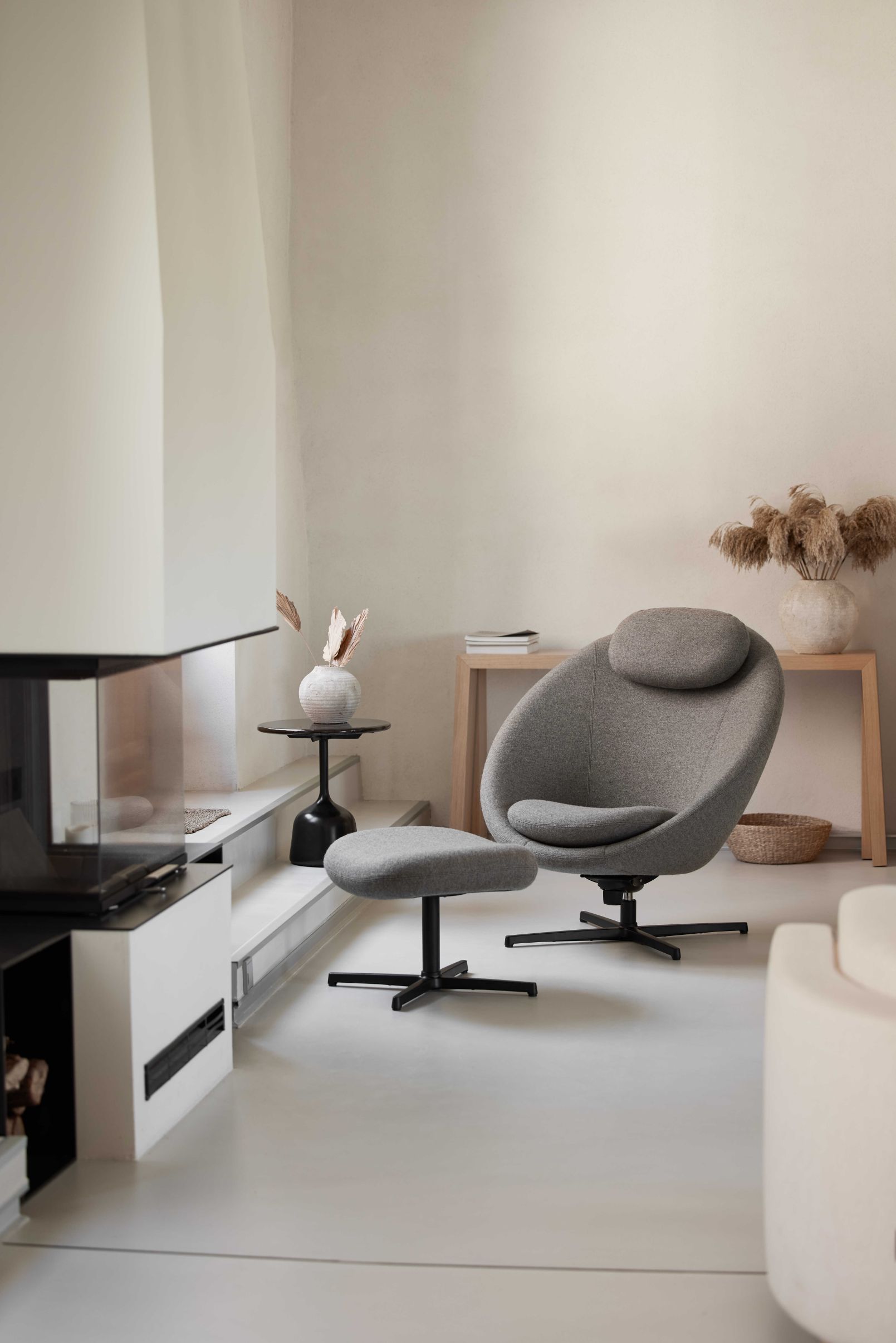 Pace Loungesessel von Cane-Line mit Hocker in grauem Stoff und schwarzem Fußgestell.