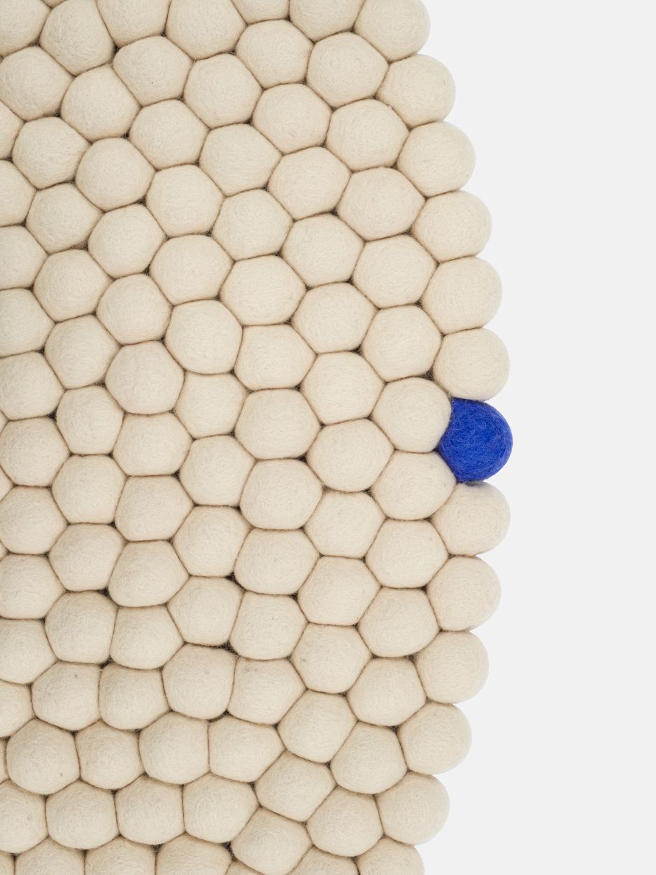 Detailansicht: Big One runder Filzteppich Ø 160 cm von myfelt in Beige mit blauer Filzkugel.