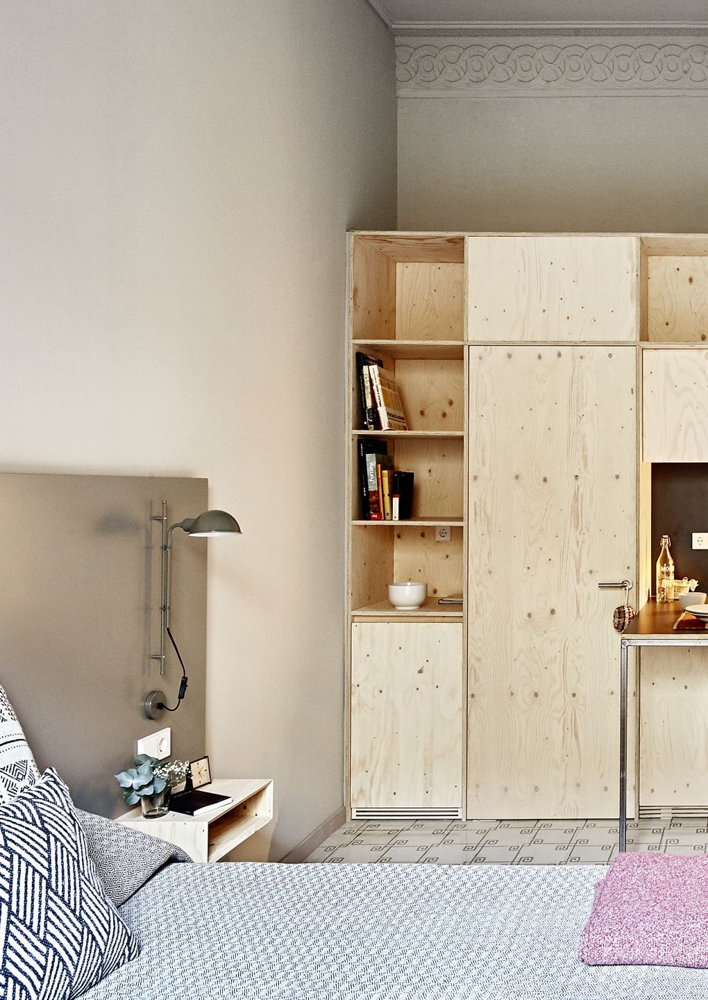 Schlafzimmer mit Funiculí A Wandleuchte in Perlweiß von Marset über Nachttisch montiert.