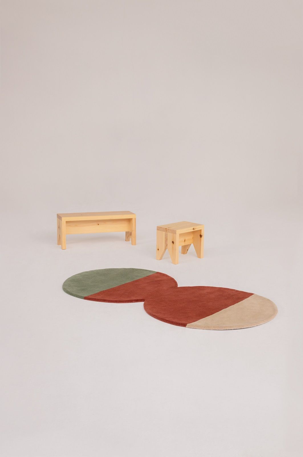 Nanimarquina Pearls Runner Teppich, runder Wollteppich in Grün, Rot und Beige mit Holzmöbeln.