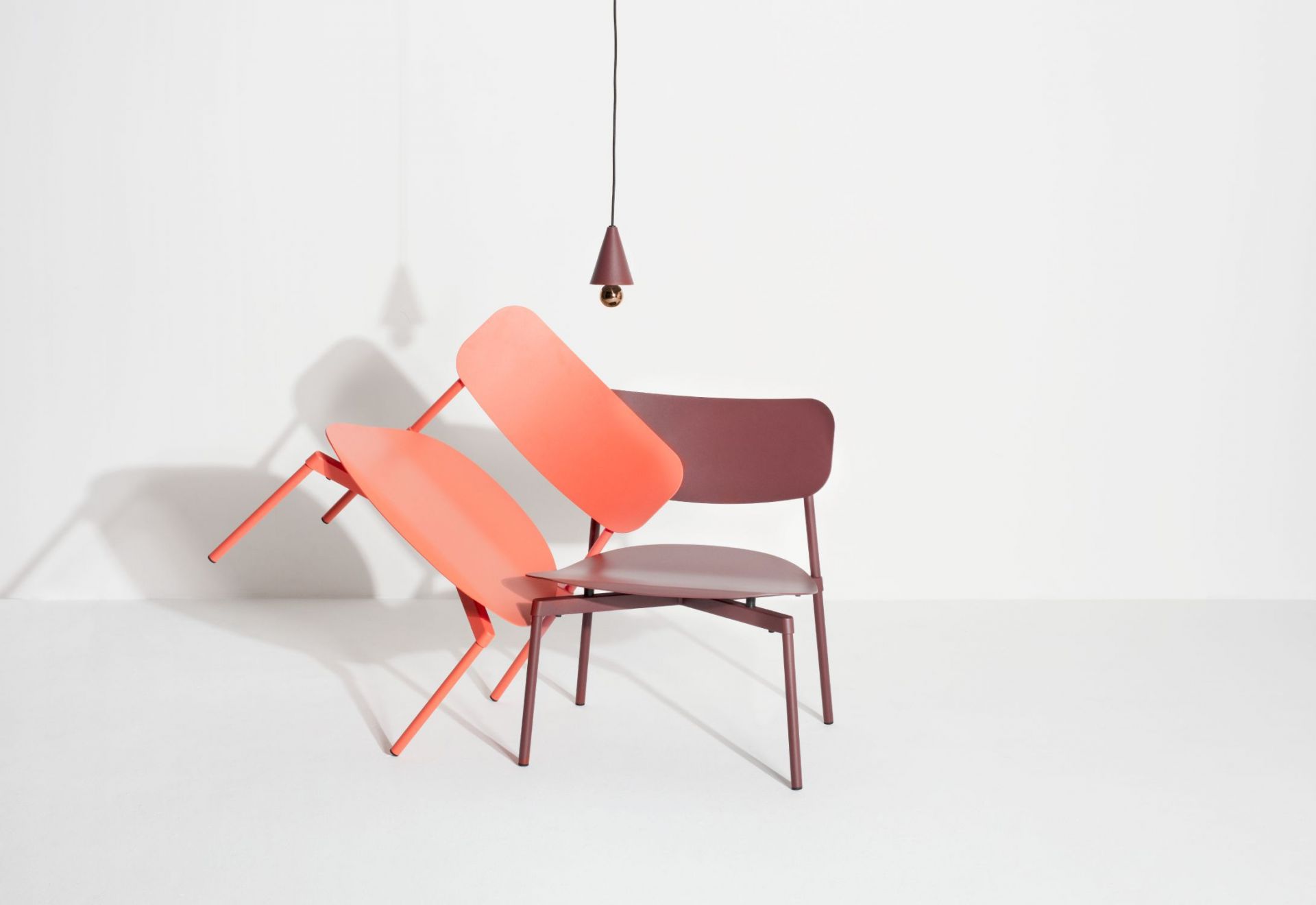 Braunrote Cherry Pendelleuchte XS von Petite Friture über zwei farbigen Stühlen. Designlampe für Wohnraum.