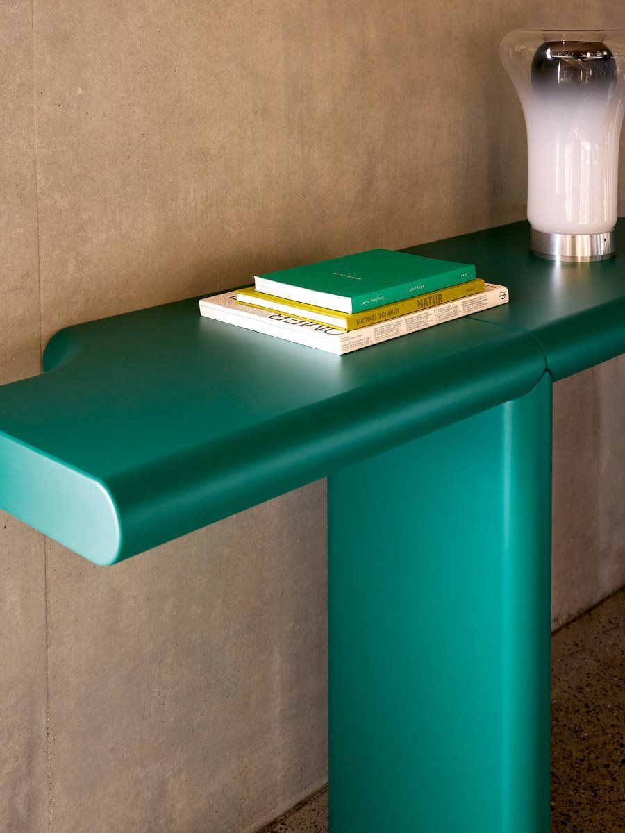 Zanotta Zavolo Wandtisch in Grün, Bücher und Lampe auf der Tischplatte, modernes Möbeldesign.