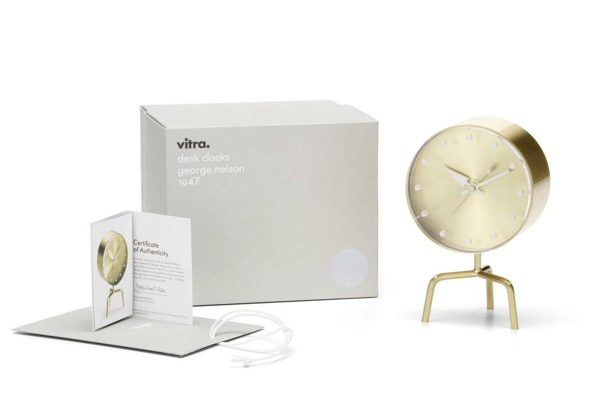 Goldene Vitra Tripod Clock Tischuhr mit drei Beinen, Verpackung und Echtheitszertifikat auf weißem Hintergrund.