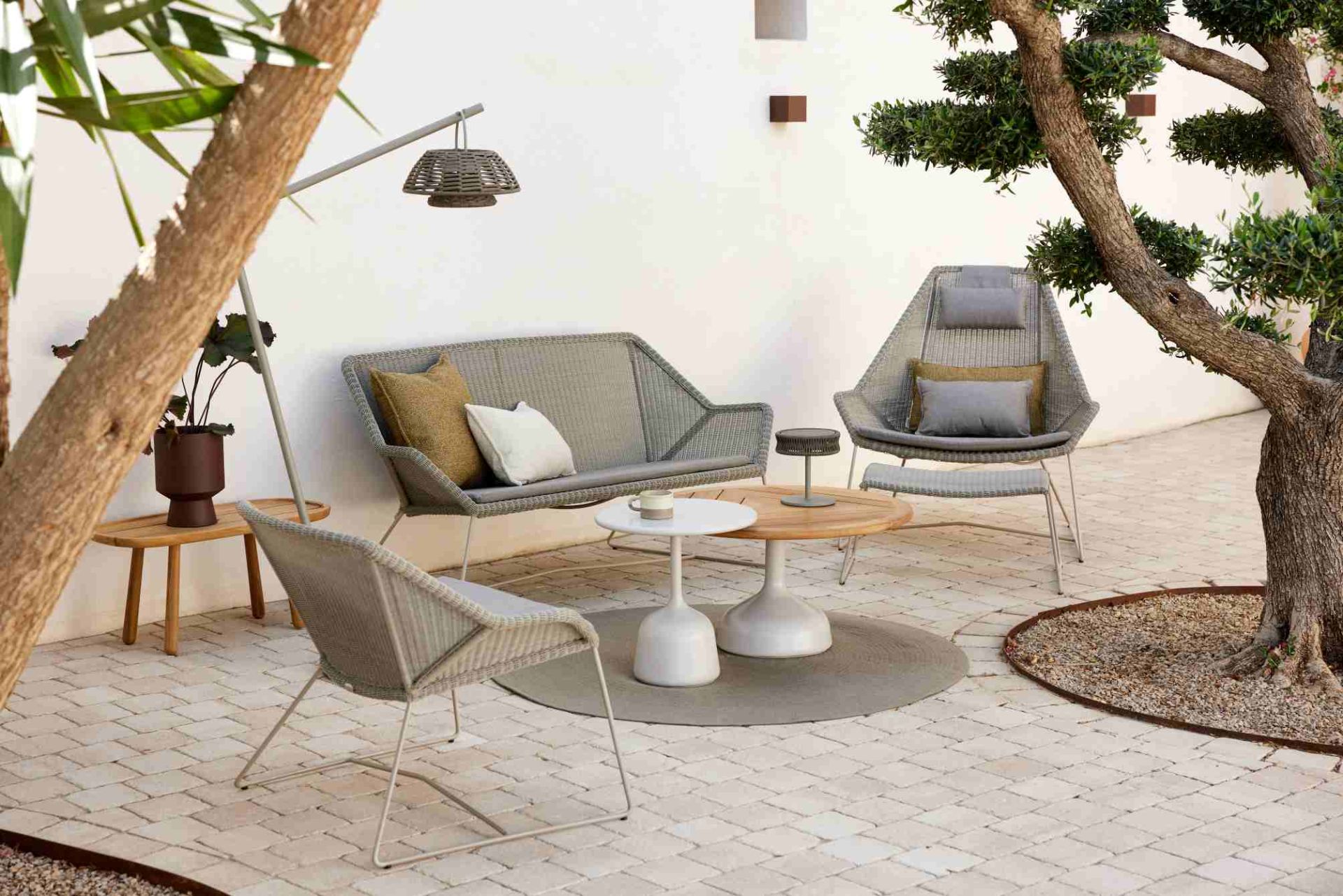 Breeze Loungesessel von Cane-Line in Taupe, Teil einer Outdoor-Lounge-Gruppe mit Tisch und Sofa.