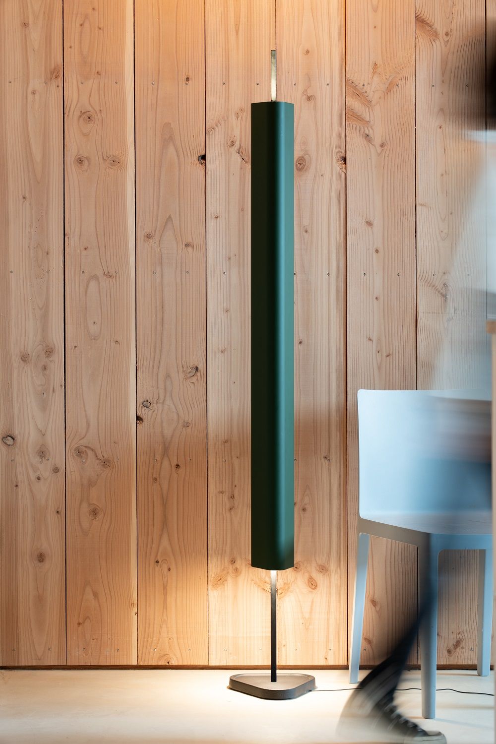 Emi Floor Stehleuchte von Flos: Moderne, grüne Stehlampe mit indirektem Licht vor einer Holzwand.