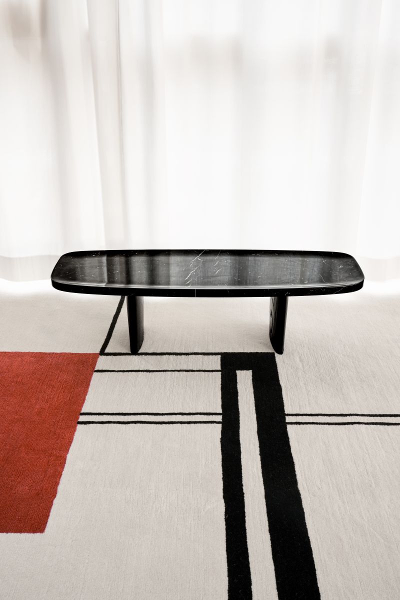 Classicon Matéria Side Table: Eleganter Beistelltisch aus schwarzem Nero Marquina Marmor auf modernem Teppich.