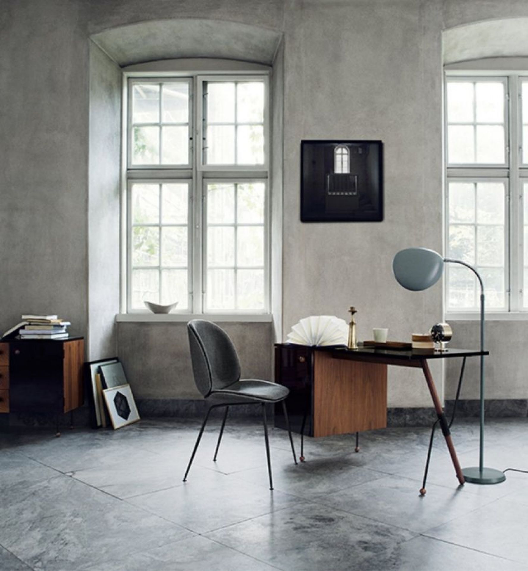 Grauer Beetle Chair Esszimmerstuhl von Gubi mit konischem Gestell in einem stilvollen Arbeitszimmer.