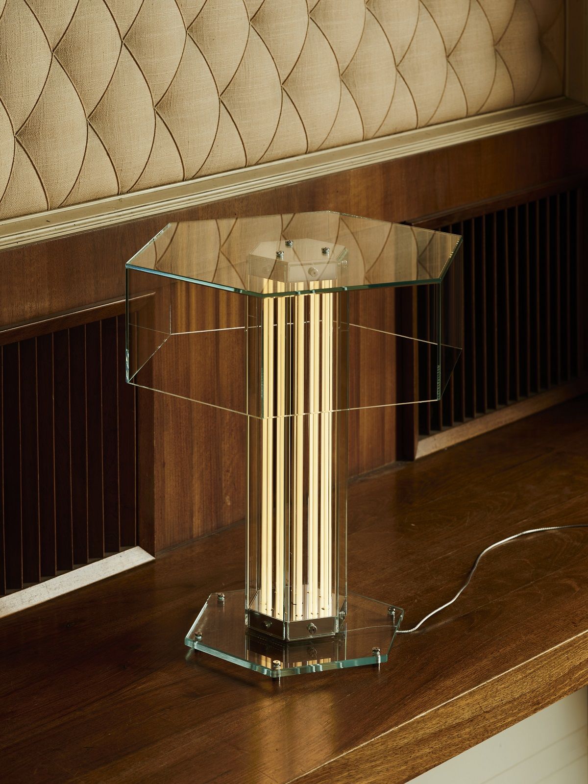 Superwire T Tischleuchte von Flos: Moderne Tischlampe mit Glas und goldenen Leuchtstäben.