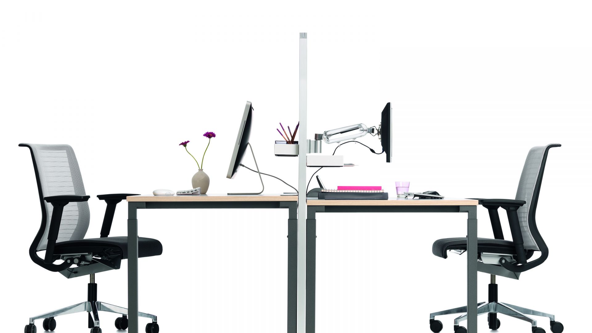 Kalidro Schreibtisch von Steelcase, höhenverstellbar, mit Bürostuhl, Monitor und Büromaterialien auf hellem Hintergrund.