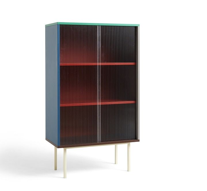 Hay Colour Cabinet Tall Schrank mit Schiebetüren und farbigen Regalböden auf weißen Füßen.
