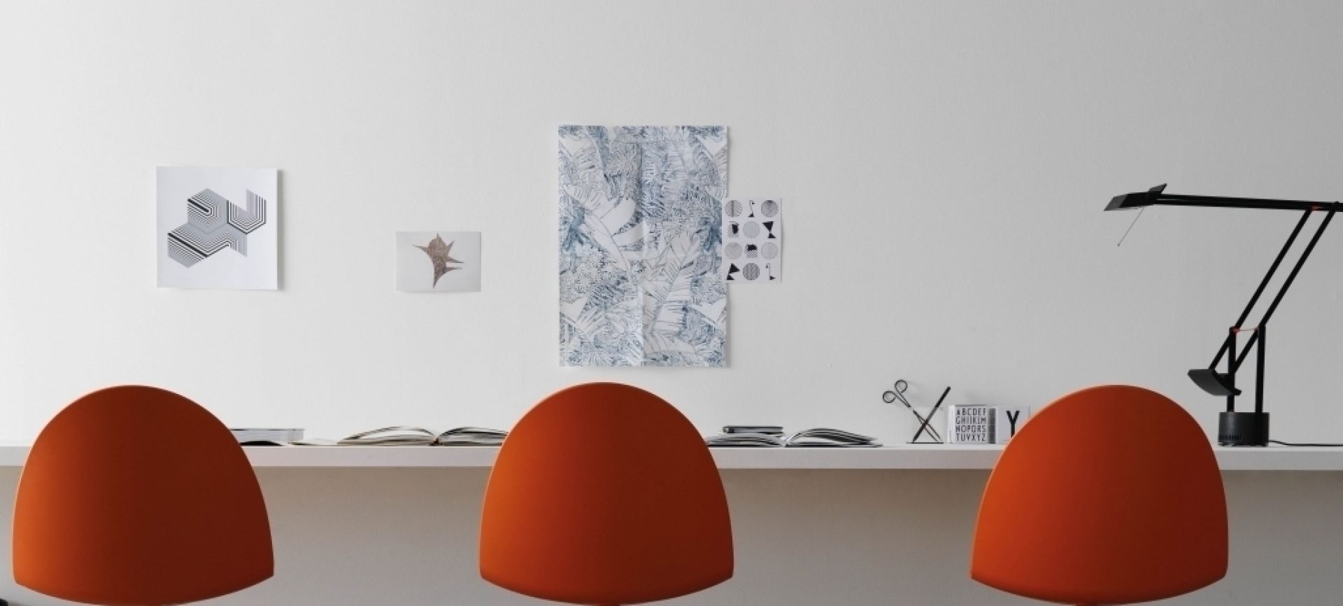 Camel Chaise Segis orange Drei orangefarbene Camel Stühle von Segis stehen an einem Schreibtisch in einem minimalistischen Büro.