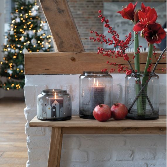 Vase d'hiver Maisons Lumière d'hiver Räder Winterliche Dekoration mit Räder Winterlicht Häuser Windlicht, roten Blumen und Granatäpfeln auf Holzbank.