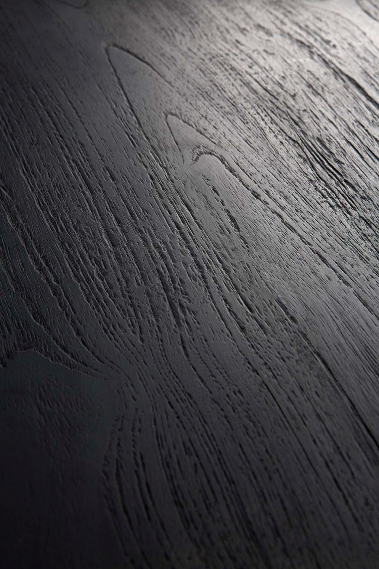 Detailaufnahme der schwarzen Eichenholz-Tischplatte des Tripod Beistelltisches von Ethnicraft, Fokus auf die markante Holzmaserung.