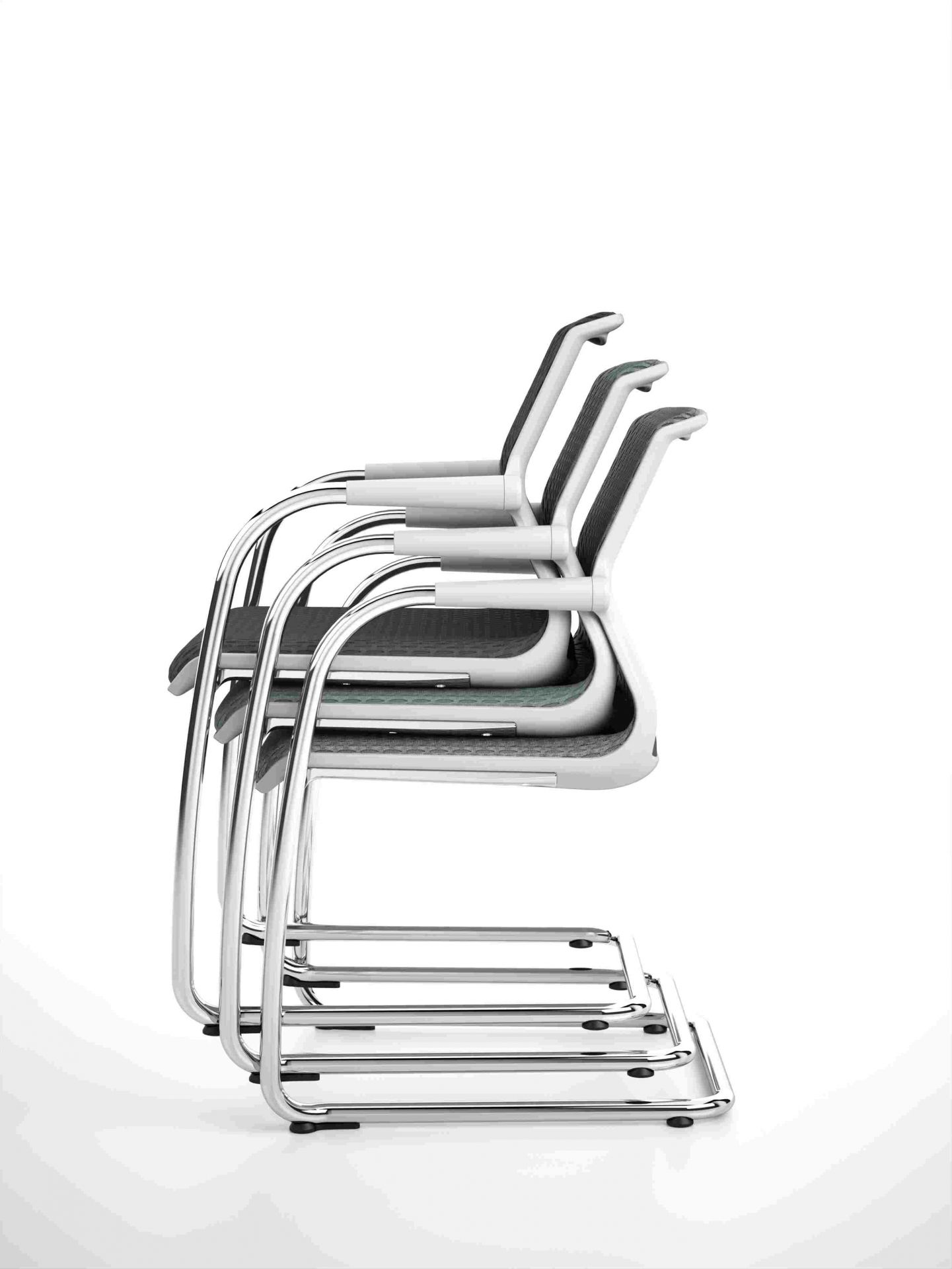 Drei graue Vitra Unix Freischwinger Stühle mit verchromtem Gestell, nicht stapelbar, in einer Reihe aufgereiht.