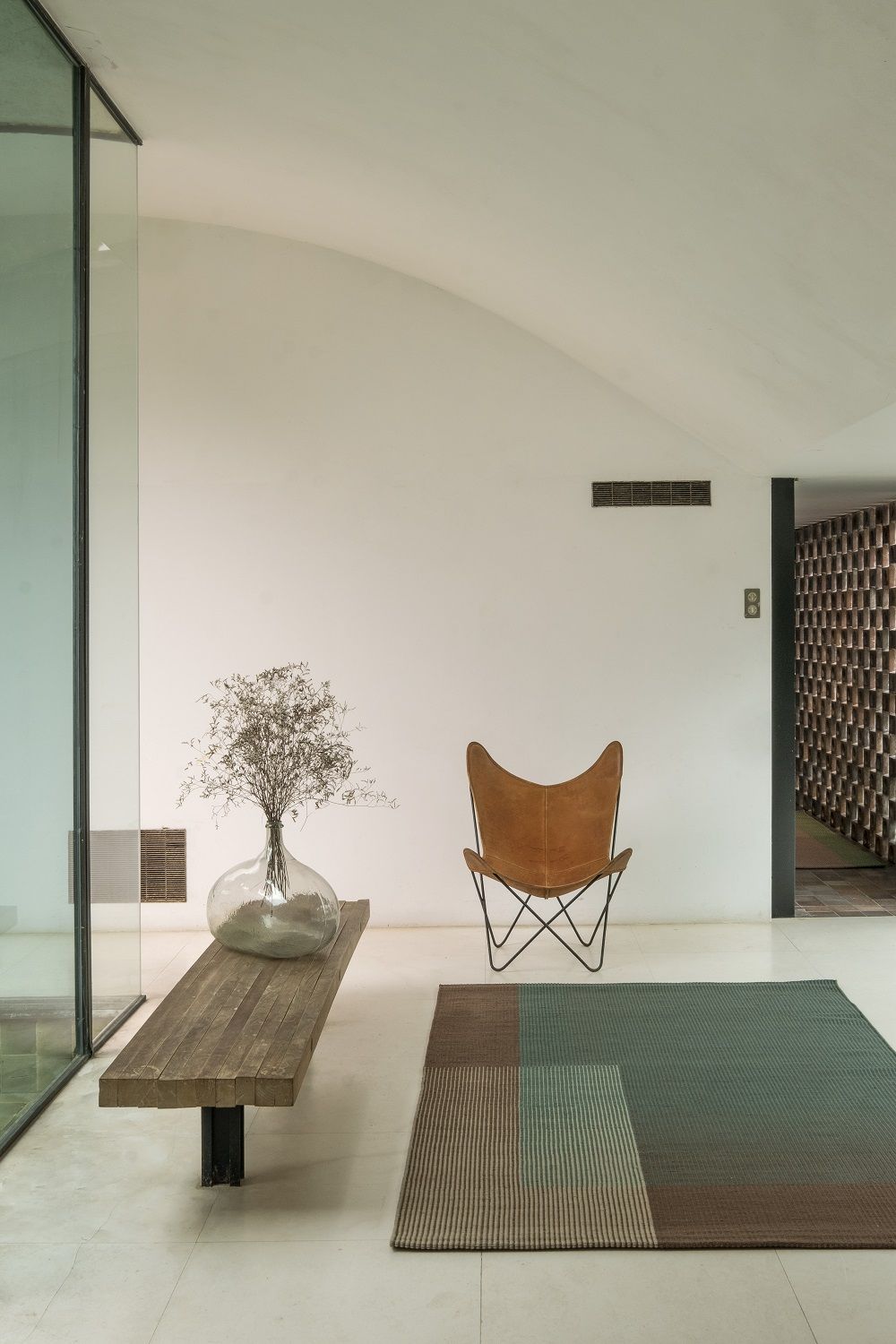 Nanimarquina Haze Rug Teppich in modernem Interieur mit Sessel und Holztisch, hochwertige Teppich- und Bodendesign-Lösung.