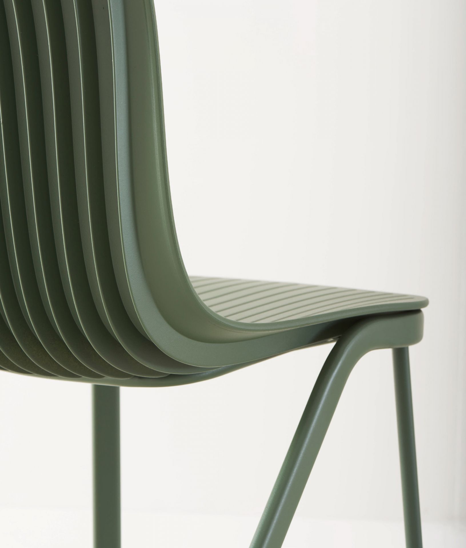 Detailaufnahme des grünen Dragonfly Stuhls mit Metallbeinen von Segis. Designstuhl für Esszimmer.