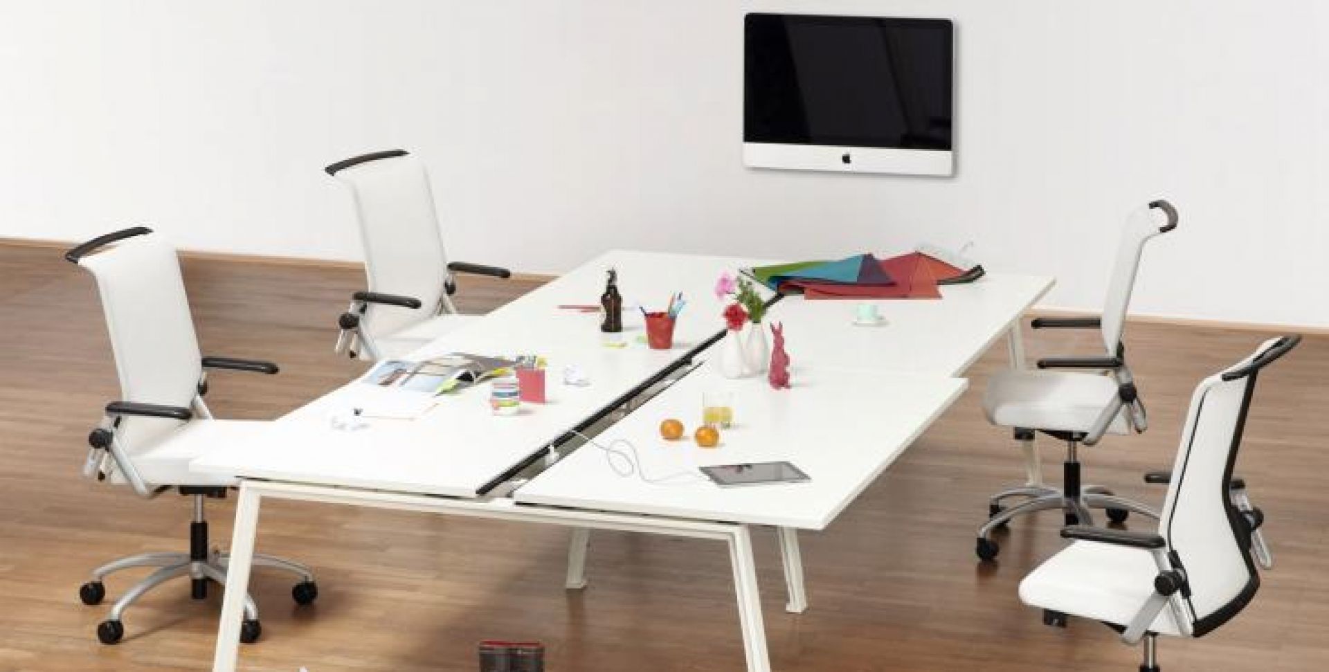 DOIT4 Konferenztisch von König+Neurath, weiß, mit vier Bürostühlen in einem hellen Konferenzraum.