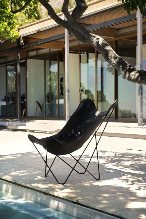 Mariposa Outdoor Butterfly Chair in Anthrazit Leder neben einem Pool. Design Gartenmöbel.