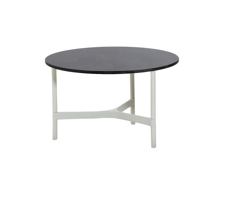 Cane-Line Twist Beistelltisch Medium in Weiß mit runder, dunkler Tischplatte und filigranem Aluminiumgestell.