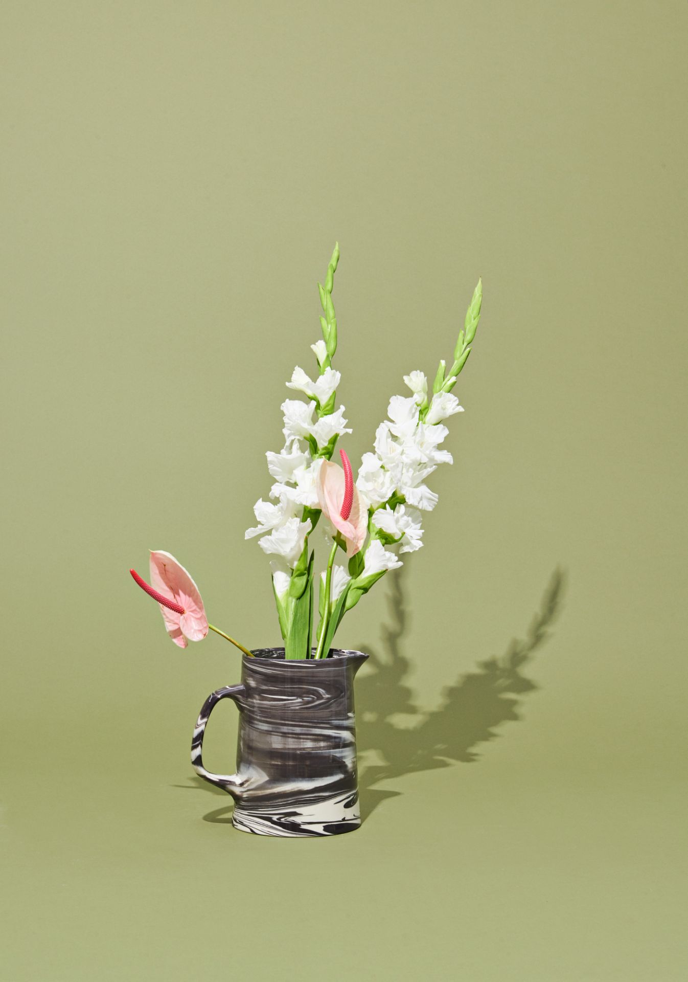 Schwarze Marbled Jug Karaffe von Hay mit Blumen auf olivgrünem Hintergrund, moderne Tischdeko.