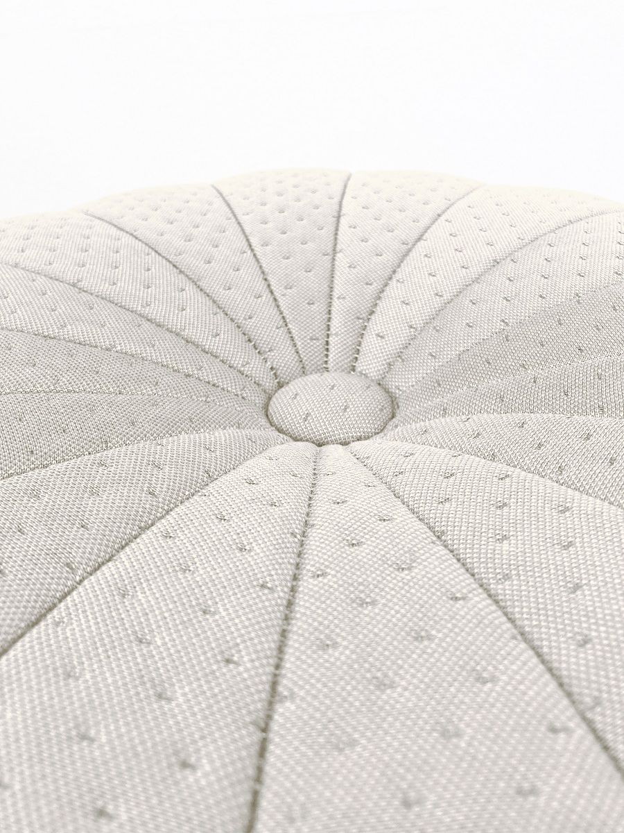 Detailaufnahme des Claudie Pouf Hockers von Hartô in Beige, mit Knopf und gesteppter Oberfläche.