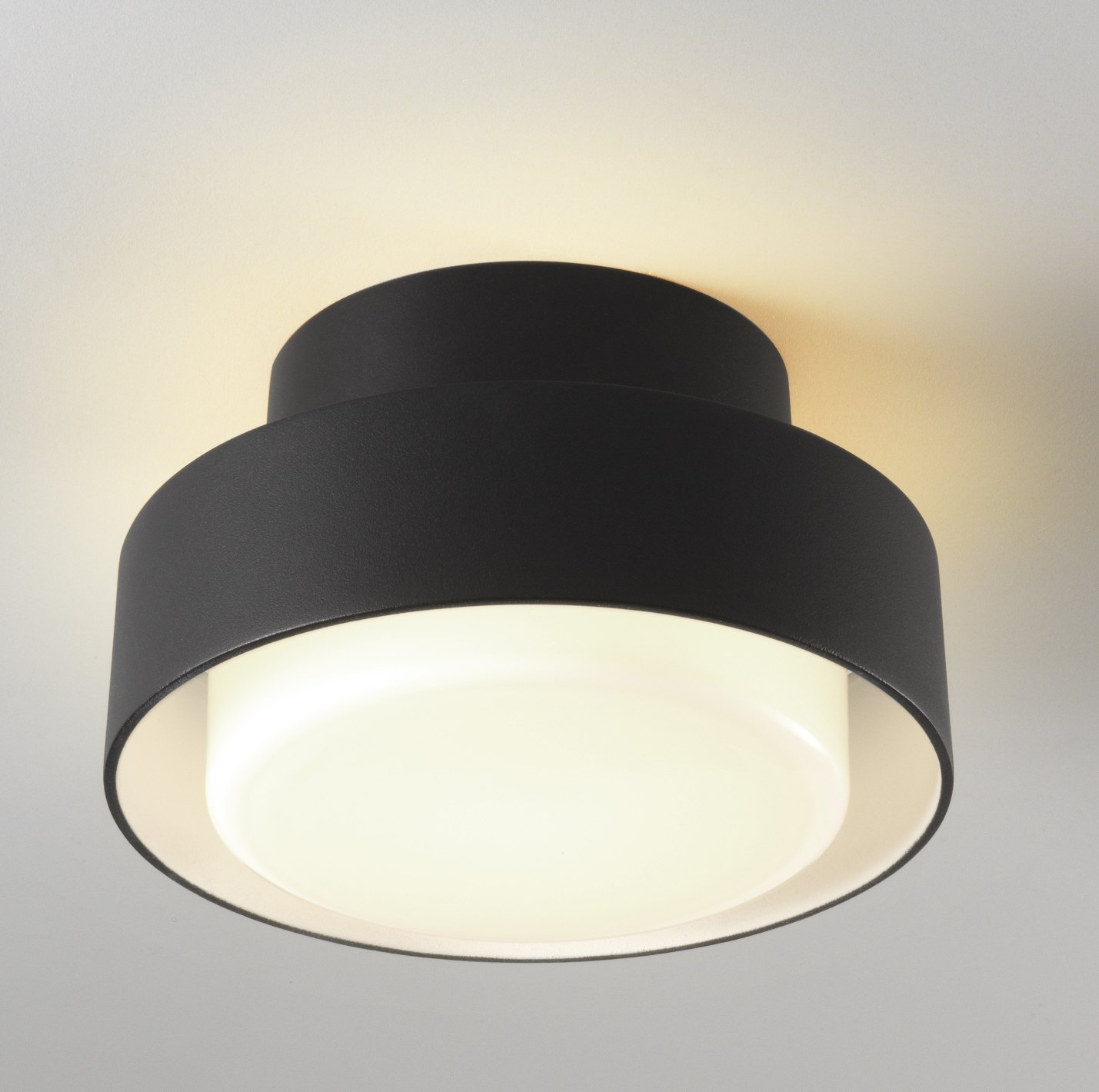 Nahaufnahme: Schwarze Plaff-On! Deckenleuchte/Wandleuchte von Marset für den Außenbereich mit warmweißem Licht.