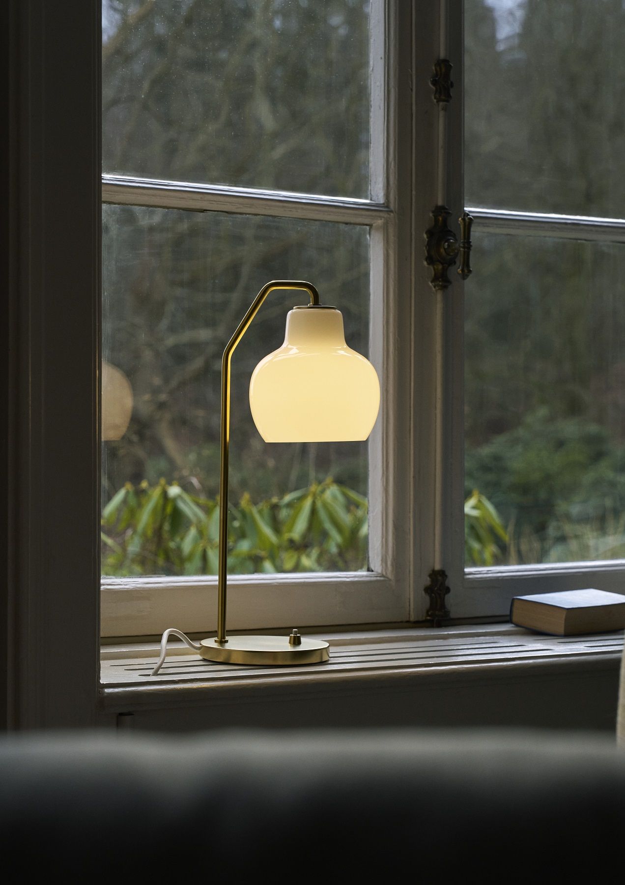 VL Ring Crown Tischleuchte von Louis Poulsen auf einer Fensterbank, warmes Licht, modernes Design.